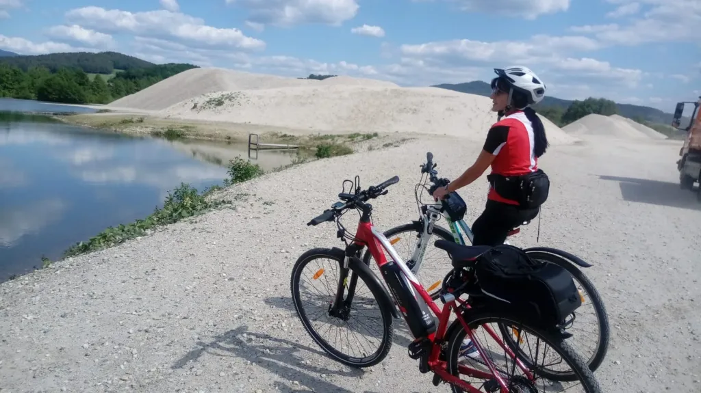 Cyclist with an e-bike taking a break by a lake
