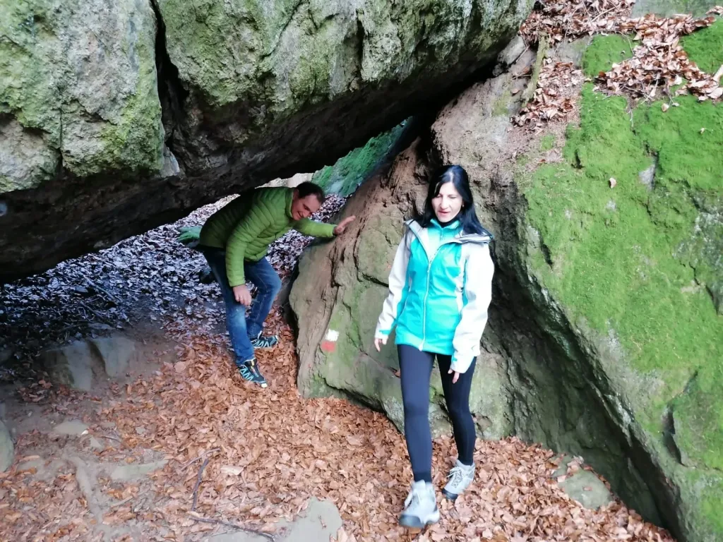 Two hikers under a rock overhang