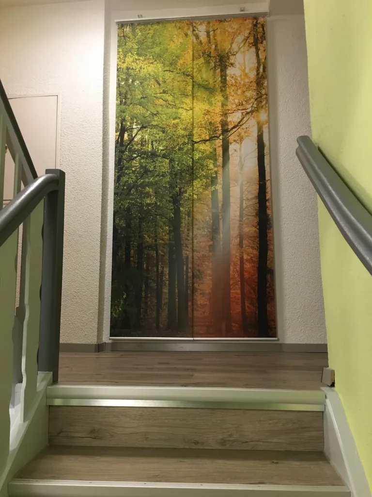 Staircase in the hotel with a large picture of a forest
