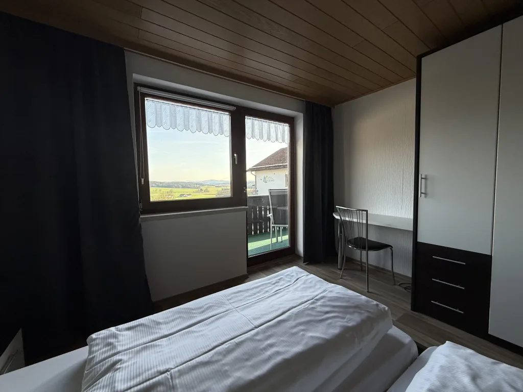Bedroom of the holiday apartment with a double bed and a window onto the balcony