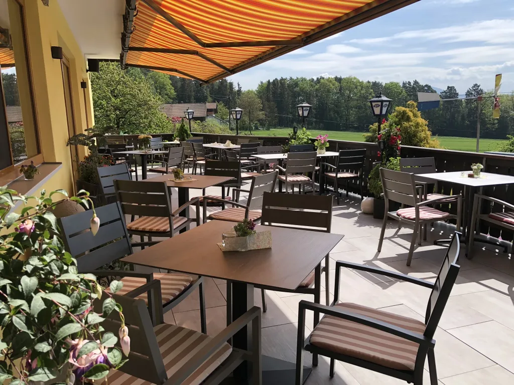 Sun terrace with tables, awning and flowers