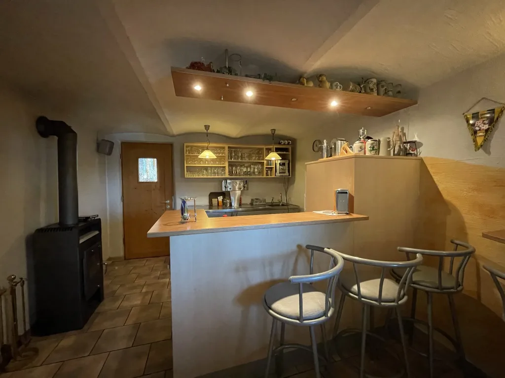 Bar counter with bar stools and a wood-burning stove
