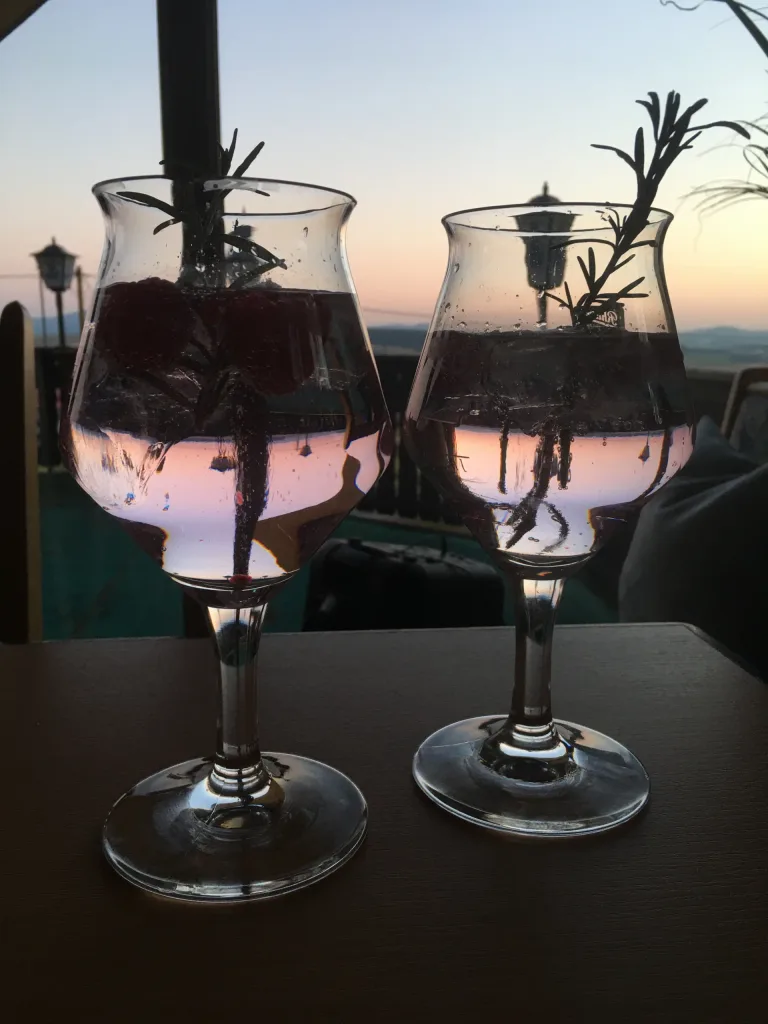 Two glasses with a sprig of rosemary in the evening light on the terrace