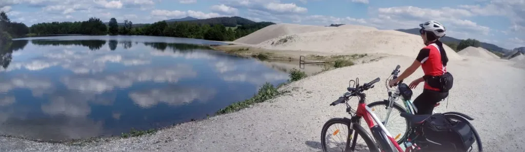Cyclist with an e-bike by a lake